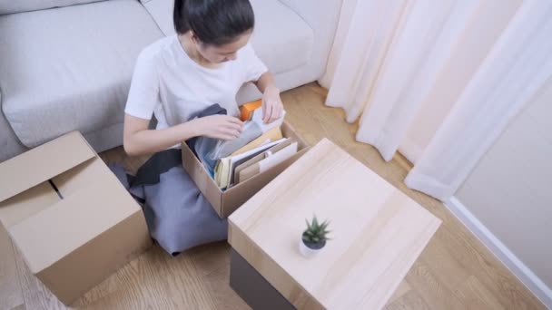 Genç Asyalı Bir Kadın Karton Kutudan Eşyaları Ayırıyor Yere Oturuyor — Stok video