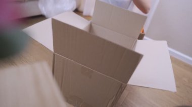 Genç bir kadın eşyalarını paket kutusuna koyar, hazırlıkları bitirir, taşınır, oda zeminine oturur, ev temizliği yapar, gönüllü bütçe krizi, basit yaşam koşulları...