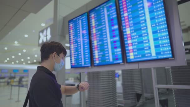 Asyalı Genç Erkek Yolcu Havaalanı Uçuş Saatine Bakıyor Uçak Bileti — Stok video