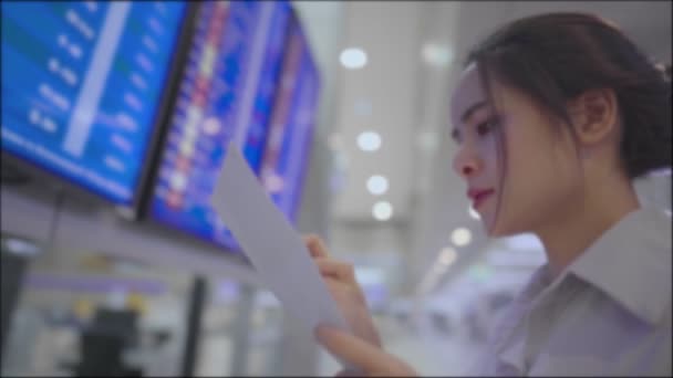 Asiatisk Ung Kvinna Står Framför Flygplatsen Flygtid Bord Kontroll Bokningsnummer — Stockvideo