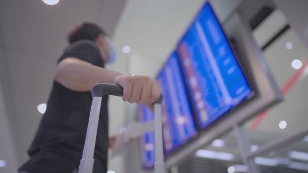Asyalı Erkek Yolcu Yüz Maskesi Takıyor Havaalanı Uçuş Saati Ekranının — Stok video