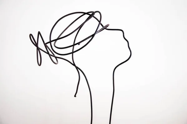 Beyaz bir duvarda kadın silueti heykeli. 