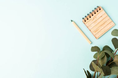 Kalem ve defterle okul pankartına geri dönüyoruz. Ofis malzemeleri ve kırtasiye malzemeleri. Nane arkaplanı ve mesaj için yeri var. Sıfır atık çevre dostu kavram.