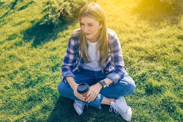 Junge Frau Mit Kopfhörern Die Bei Sonnenuntergang Auf Dem Rasen — Stockfoto