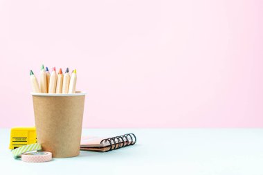 Okul pankartıyla birlikte siyah çalar saat, okul otobüsü ve kalemle. Okul gereçleri, pembe nane arkaplanındaki diğer elementler kopya alanı ile birlikte boş