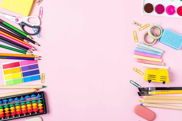 Modern pembe ofis masaüstü, okul malzemeleriyle dolu boş bir masa. Mesaj için. Okul konseptine geri dönelim. Boşluğu kopyala.