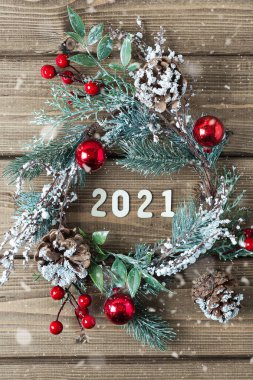Yeni yıl kompozisyonu. Köknar dallı Noel çelengi 2021 harfli, düz manzaralı, eski koyu ahşap arka planda..