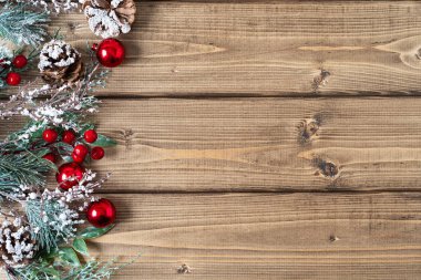 Mutlu Noel kompozisyonu. Kozalaklı dallar, böğürtlenler ve kar süslemeleri eski koyu ahşap zemin üzerinde metin için kopyalama alanı, düz üst görünüm yatıyordu.