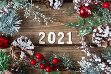 Yeni yıl kompozisyonu. Köknar dallı Noel çelengi 2021 harfli, düz manzaralı, eski koyu ahşap arka planda..