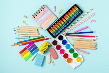 Masasında okul malzemeleri olan, modern, parlak, mavi ofis masaüstü bir daire. Üst Görünüm Okul Konseptine Dönüş.