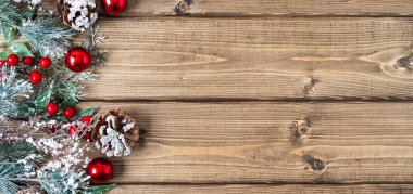 Mutlu Noel kompozisyonu. Kozalaklı dallar, böğürtlenler ve kar süslemeleri eski koyu ahşap zemin üzerinde metin için kopyalama alanı, düz üst görünüm yatıyordu.