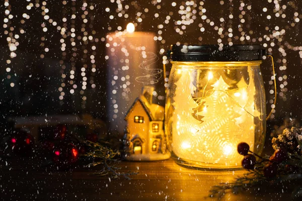 Cam kavanozda Noel ağacı, parlak ev, toplar, koni ve kartaneleri arkaplanlı simli mum. Kopya alanı olan Noel kartı dekorasyonu.