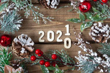 Yeni yıl 2020 'den 2021' e kadar değişiyor. Noel çelengi, köknar dallarıyla süslenmiş eski koyu ahşap arka planda, düz bir manzarası var..