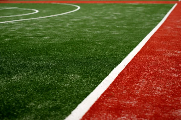 White lines on green and red artificial turf, selective view perspective.