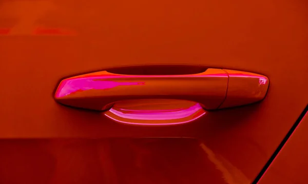 Detail of a modern red car, opalescent paint finish.