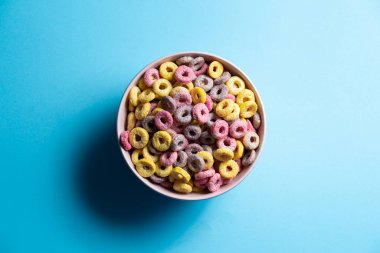 Ayrı bir kase karışık mısır gevreği ve mavi arka planda lokum.