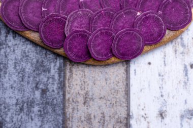 Kesme tahtasındaki doğranmış tatlı patatesin ön planı, odak dışı arka plan, sağlıklı ve ekolojik gıda