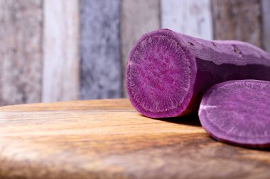 Kesme tahtasındaki doğranmış tatlı patatesin ön planı, odak dışı arka plan, sağlıklı ve ekolojik gıda