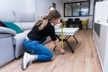 Mutfakta ölçüm masasında oturan genç bir kadın.