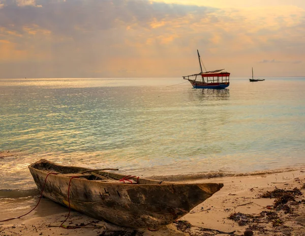 伝統的な漁師の船 ダウ船で美しいビーチは 太陽光線と日没に固定されます ビーチで前景古いボート タンザニア ザンジバル島海岸 — ストック写真