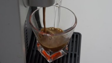 espresso kahve bir kapsül kahve makinesi ile yapılmış İtalyanca içine düşen en yüksek kalitede şeffaf cam kahve Kupası ağır çekim 120 çerçevede. kavram İtalya, sakin ol, biyo ve doğa.