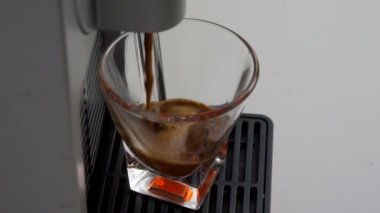 espresso kahve bir kapsül kahve makinesi ile yapılmış İtalyanca içine düşen en yüksek kalitede şeffaf cam kahve Kupası ağır çekim 60 çerçevede. kavram İtalya, sakin ol, biyo ve doğa.