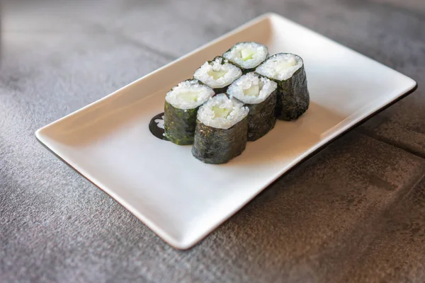 Komkommer Sushi Geserveerd Rechthoekige Witte Plaat Donkere Grijze Stenen Achtergrond — Stockfoto