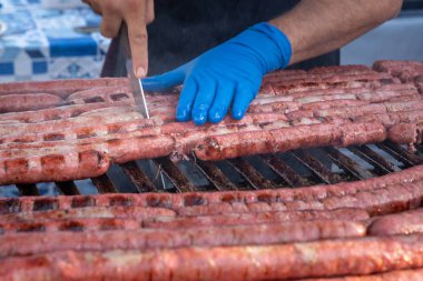 Barbekü ve kişi sosis kesme