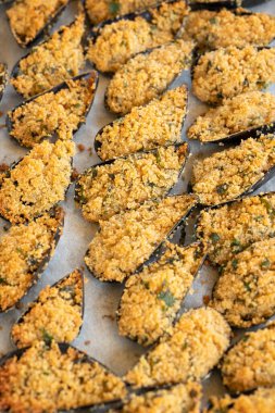 Gratin usulü midyeler beyaz arka planda izole edilmiş.