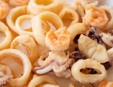 Beyaz arka planda izole edilmiş kızarmış mürekkep balığı veya ahtapot (kalamar) ve karides.