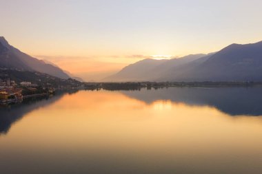 Güneşin doğuşunda İseo Gölü 'nün drone görüntüsü, solda, göl boyunca uzanan Lovere şehri, Bergamo İtalya..