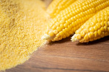 Olgun taze mısır koçanı, sol üst üste ahşap arka planda, yakın plan. Glütensiz gıda kavramı.