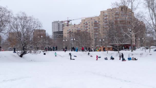 传统的俄罗斯冬季乐趣滑雪 孩子们在湖岸上乘坐滑梯 3840X2160 — 图库视频影像