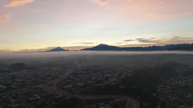 Güneşin doğuşunda volkanla birlikte Foggy Landscape 'in insansız hava aracı görüntüsü. Yüksek kalite 4k görüntü