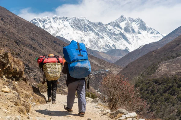 Porter carrying heavy loads walk to Everest base camp, Himalaya mountain, Nepal, Asia