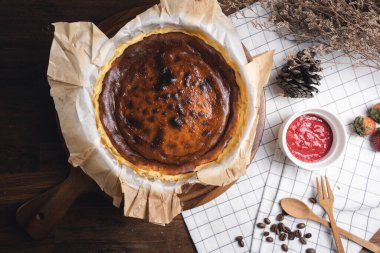 Çilekli ev yapımı peynirli kek, çilek reçeli, kahve çekirdeği ve ahşap masa çatalı. Ev yapımı fırın konsepti