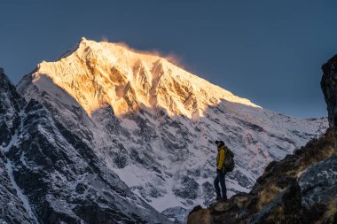 Genç bir Asyalı kadın, sabahleyin Himalaya dağının önünde duruyor. Langtang Vadisi, Nepal, Asya 'da.
