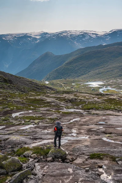 在欧洲斯堪的纳维亚奥德达镇著名的旅行路线 特罗尔通加山崖 一个背着背包旅行的亚洲年轻人 — 图库照片