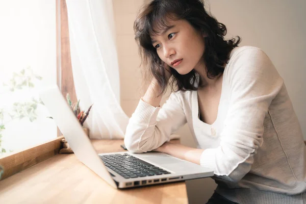 아시아인 근로자가 컴퓨터로 일하고 있습니다 집에서 일하는 생각을 압박감을 느끼는 스톡 사진