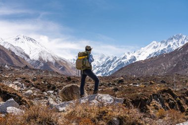 Sırt çantalı genç Asyalı yürüyüşçü Langtang Vadisi 'nde Himalaya dağlarında Nepal, Asya' da seyahat eden bir kadın.