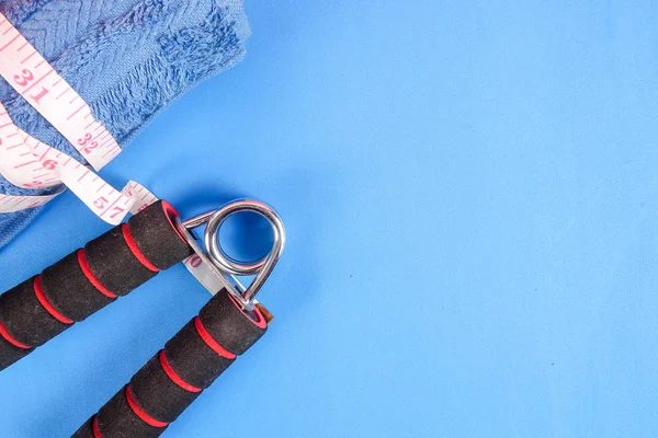 ダンベル ハンド グリップ 青の背景に測定テープとフィットネスの概念 — ストック写真