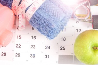 Fitness kavramı halter, el tutma, kule ve takvim arka plan üzerinde ölçüm bandı ile.