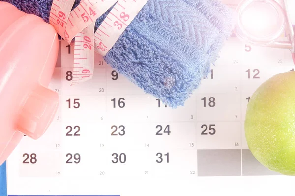 Fitness kavramı halter, el tutma, kule ve takvim arka plan üzerinde ölçüm bandı ile.