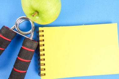 Fitness kavramı halter, el tutma, kule ve mavi bir arka plan üzerinde ölçüm bandı ile.