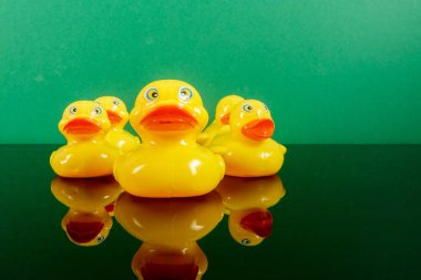 Ördekler yeşil arka plan üzerinde yansıması ile büyük ördek takip grubu. Liderlik kavramsal.