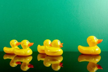 Ördekler yeşil arka plan üzerinde yansıması ile büyük ördek takip grubu. Liderlik kavramsal.