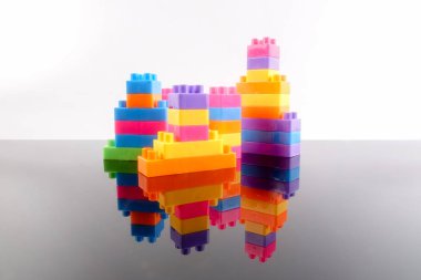 Plastik yapı taşları yansıması ile beyaz arka plan üzerinde izole.