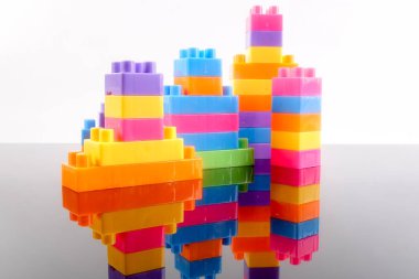 Plastik yapı taşları yansıması ile beyaz arka plan üzerinde izole.