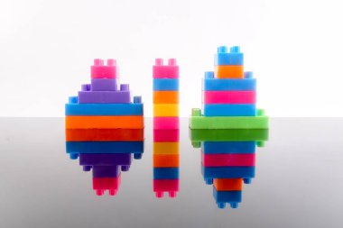 Plastik yapı taşları yansıması ile beyaz arka plan üzerinde izole.