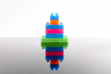 Plastik yapı taşları yansıması ile beyaz arka plan üzerinde izole.